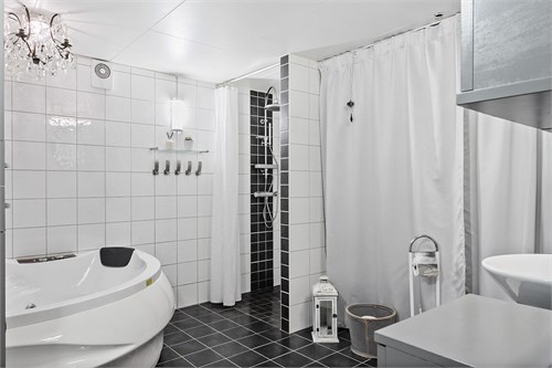 Helkaklat och stilrent badrum på nedre plan