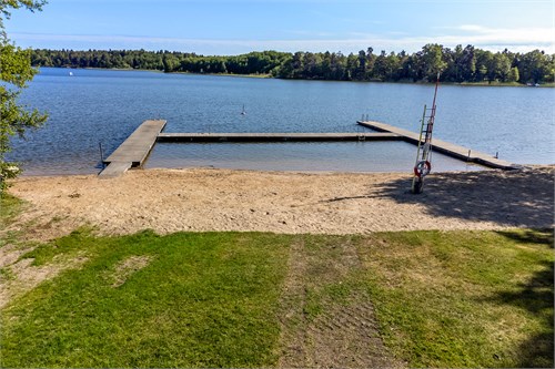 Badrocksavstånd till sandstrand med bryggor