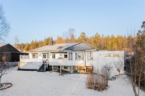 Husets baksida med inglasad altan med solterrass