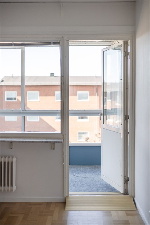 Utgång till inglasad balkong mot innergården