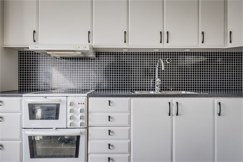 Tidlöst vitt kök med svarta detaljer