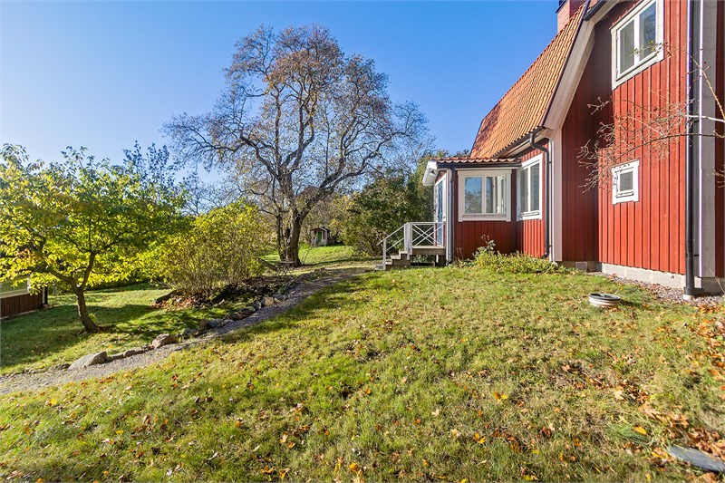 Idyllisk trädgård sträcker sig runtom husen